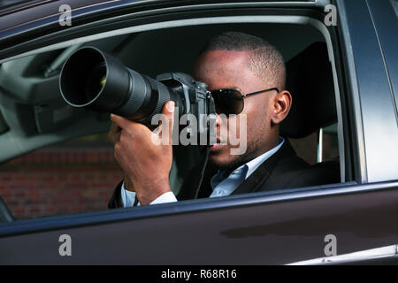 Detektiv Sitzen im Auto Fotografieren Stockfoto