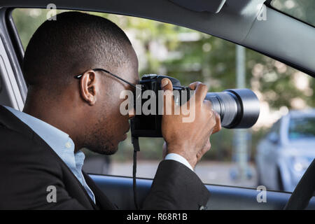 Privatdetektiv Sitzen im Auto Fotografieren Stockfoto