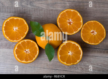 Frische reife Tangerinen mit Blättern, die auf einer hölzernen Hintergrund. Ansicht von oben. Stockfoto