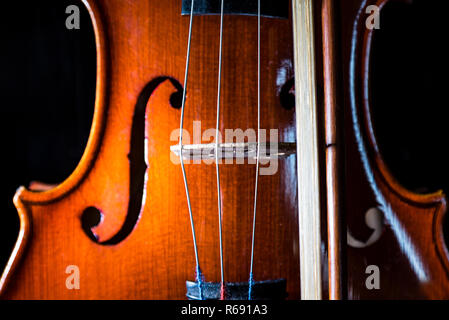 Violine mit Geige Bogen vor einem schwarzen Hintergrund, Nahaufnahme, still life Fotografie Stockfoto