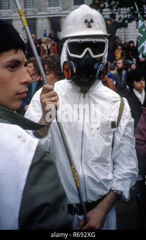 Demonstration von Atomkraftgegnern im London der 1980er-Jahre mit demonstrant tragen weiße Blaumann und nukleare weißen Helm Stockfoto