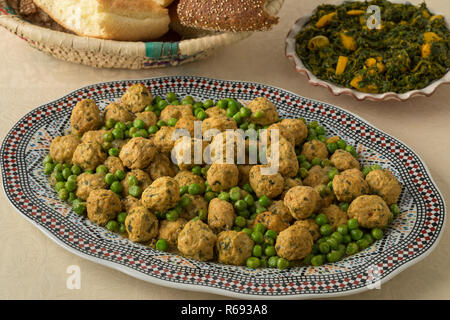 Schale mit marokkanischen Stil Hackfleisch Huhn Kugeln und grünen Erbsen, Spinat, Salat und Brot Stockfoto