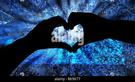 Silhouette Hände in Herzform und Papiere während eines Konzerts Stockfoto