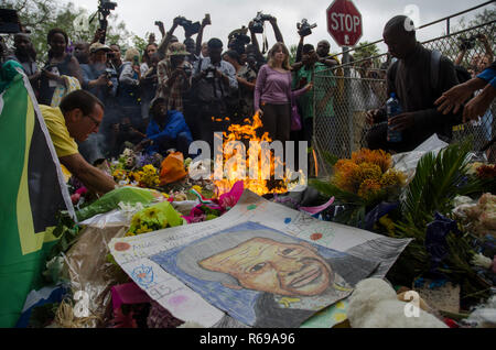 Blumen und Bilder links außerhalb des ehemaligen Präsidenten Nelson Mandela's House in Houghton steigen Sie mit Kerzen trauernden' gesetzt, in Johannesburg, Freitag, 6. Dezember 2013. Die Elder statesman starb am Donnerstag, 5. Dezember 2013. Foto: EVA-LOTTA JANSSON Stockfoto