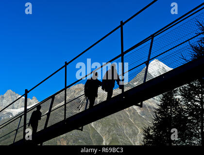 Wanderer gegen die Hintergrundbeleuchtung auf dem Charles Kuonen Suspension Bridge, Randa, Wallis, Schweiz Stockfoto