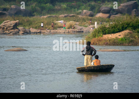 Zwei Männer mit einem handgefertigten traditionellen Tungabhadra Coracle Boot den Fluss zu überqueren, Hambi, Indien. Stockfoto