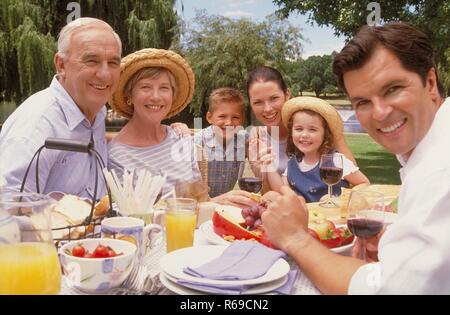 Parkszene, Porträt, 3 Generationen einer Familie geniessen einen Sommertag im Grünen bei einem Picknick Stockfoto