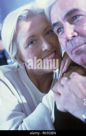 Porträt, Nahaufnahme, Zaertliches Paar Mitte 50, blonde Frau mit hellem Hemd und weisshaariger Mann mit schwarzem Shirt Stockfoto