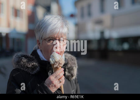 Eine ältere Dame mit einer Portion Eis Stockfoto