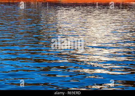 Reflexionen von einem Schiff werfen interessante Muster auf dem Wasser Stockfoto