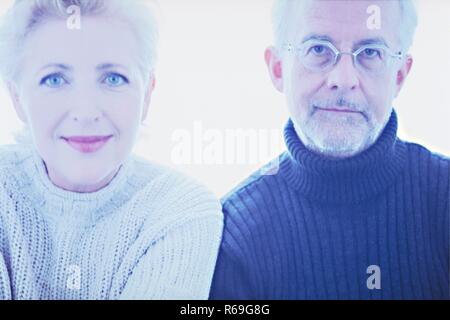 Porträt, Nahaufnahme, Paar Mitte 50, blonde Frau und grauhaariger Mann mit Bart und Brille, beide bekleidet, mit dickem Pullover, Artikel nebeneinander Stockfoto