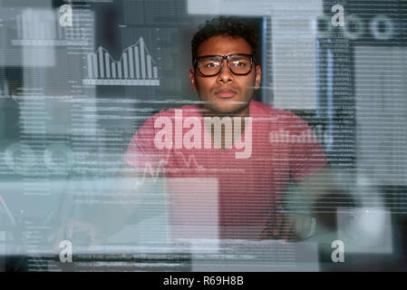 Junger Brillenbär konzentriert indischen Big Data Entwickler Stockfoto