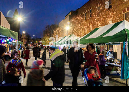 Nacht geschossen von Menschen flanieren durch ein Markt im Freien mit Weihnachtsbeleuchtung illuminiert, Navigator Square, Torbogen, London, UK Stockfoto