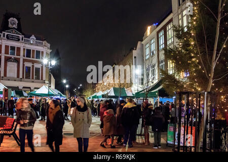 Nacht geschossen von Menschen flanieren durch ein Markt im Freien mit Weihnachtsbeleuchtung illuminiert, Navigator Square, Torbogen, London, UK Stockfoto