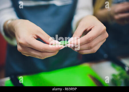 Gerichte mit Kräutern, Mädchen wraps Blätter grün in einem Stroh Stockfoto