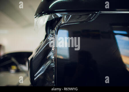 Arbeiter Hände installiert Auto Lackschutz Folie wickeln. Stockfoto