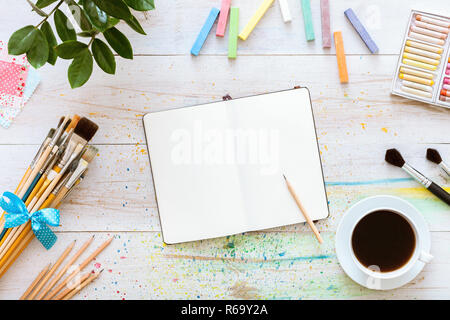 Flat Style künstlerische Gestaltung Arbeitsbereich, leer Notebook mock up für kreative Skizzen mit Aquarellfarben, Bleistift, Pinsel und Tasse Kaff eingestellt Stockfoto