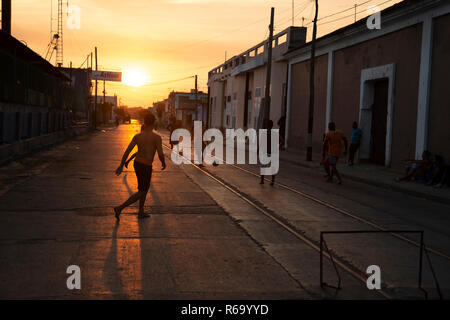 Silhouetten der kubanischen Jungen spielen Straßenfußball, wie die Sonne hinter Ihnen in Cienfuegos Kuba Stockfoto