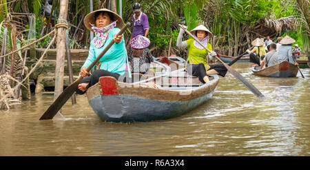 MY THO, VIETNAM - November 24, 2018: Vietnamesische Frauen in der traditionellen Vietnamesischen cap Paddel ein kleines Boot mit Touristen auf dem Mekong Fluss in meinem Th Stockfoto