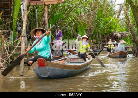 MY THO, VIETNAM - November 24, 2018: Vietnamesische Frauen in der traditionellen Vietnamesischen cap Paddel ein kleines Boot mit Touristen auf dem Mekong Fluss in meinem Th Stockfoto