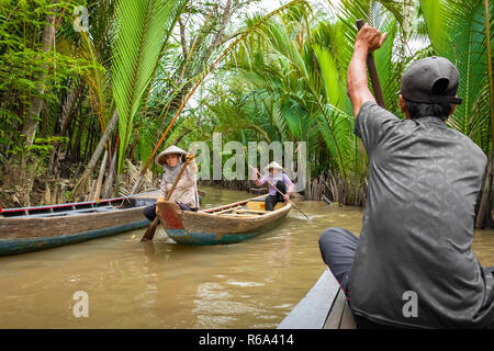 MY THO, VIETNAM - November 24, 2018: Mekong Delta Jungle Cruise mit nicht identifizierten craftman und Fisherman Ruderboote auf Überschwemmungen schlammigen Lotus fi Stockfoto