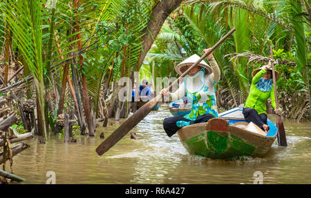 MY THO, VIETNAM - November 24, 2018: Vietnamesische Frauen in der traditionellen Vietnamesischen cap Paddel ein kleines Boot mit Touristen auf dem Mekong Fluss in meinem Th Stockfoto