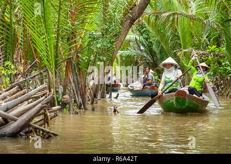 MY THO, VIETNAM - November 24, 2018: Vietnamesische Frauen in der traditionellen Vietnamesischen cap Paddel ein kleines Boot mit Touristen auf dem Mekong Fluss in meinem Th Stockfoto