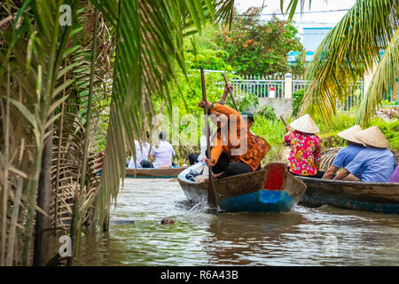 MY THO, VIETNAM - November 24, 2018: Vietnamesische Frauen in der traditionellen Vietnamesischen cap Paddel ein kleines Boot mit Touristen auf dem Mekong Fluss in meinem Th Stockfoto