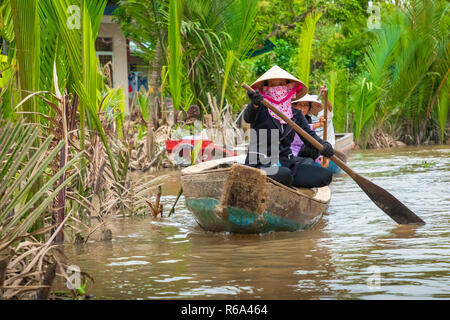 MY THO, VIETNAM - November 24, 2018: Vietnamesische Frauen in der traditionellen Vietnamesischen cap Paddel ein kleines Boot mit Touristen auf dem Mekong Fluss in meinem Th Stockfoto