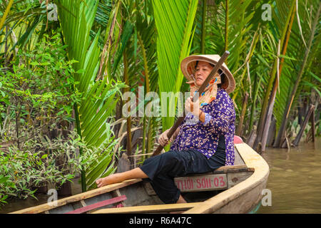 MY THO, VIETNAM - November 24, 2018: Vietnamesische Frauen in der traditionellen Vietnamesischen cap Paddel ein kleines Boot mit Touristen auf dem Mekong Fluss in meinem Th Stockfoto