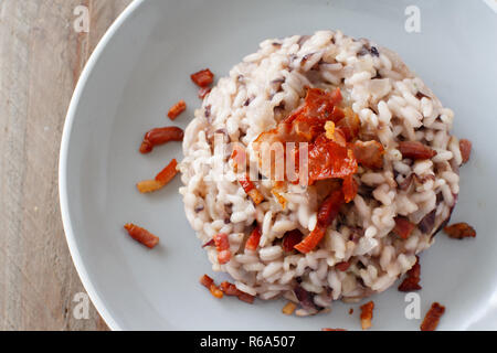 Risotto mit rotem Radicchio und knusprigem Speck (Speck) Stockfoto