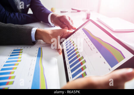 Zwei Geschäftsleute arbeiten gemeinsam an finanziellen Graph Stockfoto