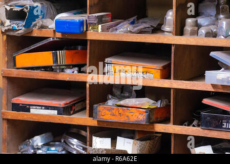 Alte Rad muttern und andere Teile aus Metall Kartons und Container auf Regalen in einem Workshop gespeichert Stockfoto