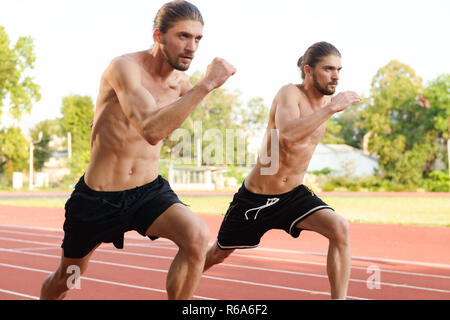 Image der Jungen zwei Zwillinge Sportler Brüder im Stadion im Freien läuft. Stockfoto