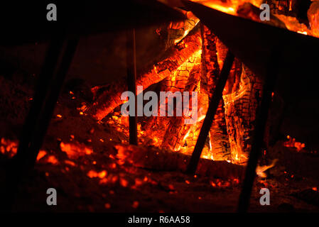 Das Feuer entzünden. Erwärmung des kalten Winternächten. Eine Makroaufnahme von Brennholz, weißen Staub und warme, glühende Kohle. Brennende Äste und Holz. Flammen in t Stockfoto