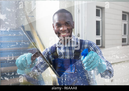 Männliche Arbeiter Reinigung Glas mit Rakel Stockfoto