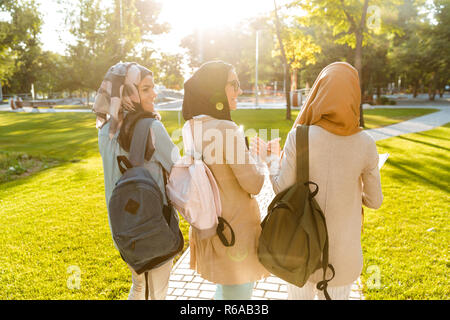 Rückansicht Bild der glücklichen Freunde muslimischen Schwestern Frauen draußen halten Bücher. Stockfoto