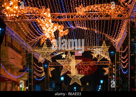 Verschwommene, abstrakte Weihnachten Hintergrund. Glühende Rentier, Sterne und helle Streifen auf dunkle, romantische Nacht Himmel Hintergrund. Weihnachtsmarkt und Dekoration Stockfoto