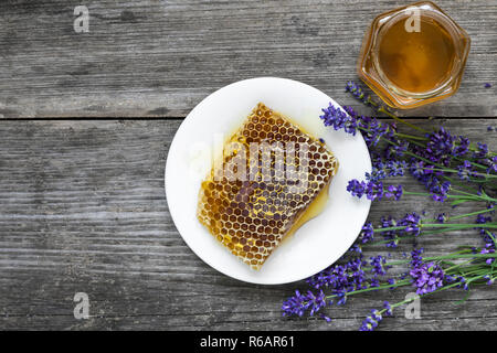 Honig mit Lavendelblüten und Waben auf rustikalen Holztisch. gesundes Essen. top View Stockfoto