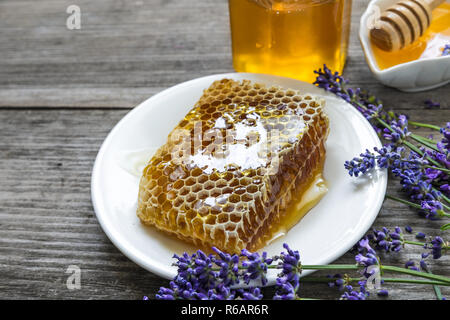 Honig mit Lavendelblüten und Waben auf rustikalen Holztisch. Gesundes essen. Nach oben Schließen Stockfoto