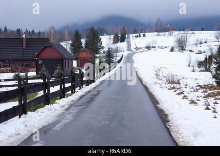 Straße in Bieszczady zu Wetlina und Solina, Winter mit viel Schnee. Gebäude im Hintergrund Stockfoto