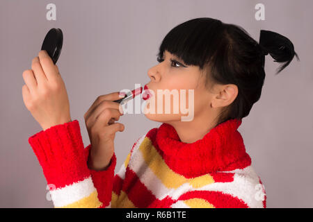 Frau nimmt Lippenstift Stockfoto