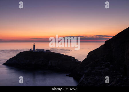 South Stack Leuchtturm in der Dämmerung an der Küste von Anglesey, Nordwales Stockfoto