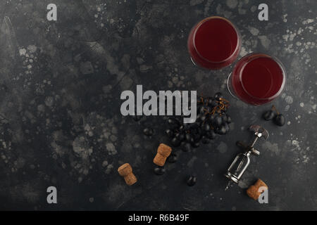 Rotwein mit Trauben auf einem dunklen Hintergrund. Ansicht von oben mit Platz für Text. Stockfoto