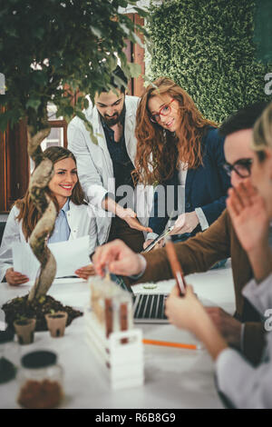 Clevere progressive junge Ingenieure arbeiten an digitalen Tablet auf einer ökologischen Bauvorhaben im Büro, reden über einige grüne Projekt. Stockfoto