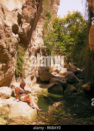 (Avgas) Avakas Schlucht, Paphos, Zypern: Schlucht mit Pool und weibliche Wanderer ruht auf einem Felsen. MODEL RELEASED Stockfoto