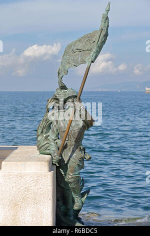 TRIESTE, Italien - 14. Oktober: Le Bronze Soldat Statue mit Flagge in Triest am 14. Oktober 2014. Le Bronze Skulptur, eines der Symbole der Stadt, r Stockfoto