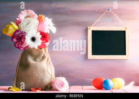 Blumenstrauß mit bemalten Eiern und eine Tafel Stockfoto