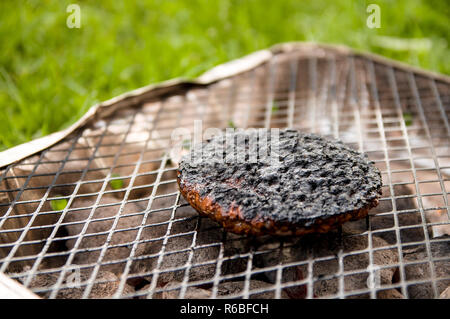 Nahaufnahme einer verbrannten Burger auf einem Grill im Park. Selektive konzentrieren. Stockfoto