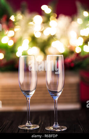 Neujahr oder Weihnachten grün hinterlegt. Niederlassungen der Weihnachtsbäume mit Golden Lights, Girlanden, Spielzeug und leeren sektgläser eingerichtet. Stockfoto